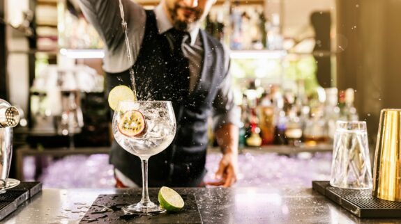 a man pouring a drink into a glass