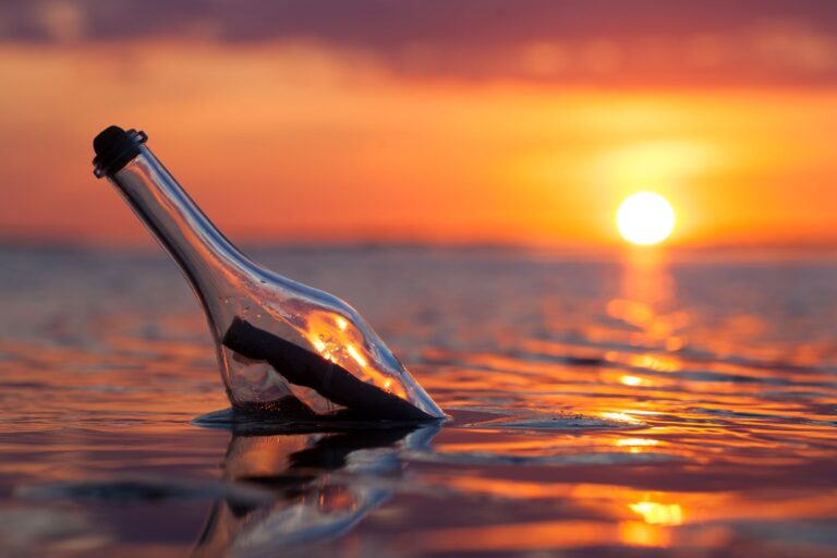 A Bottle In The Water With A Sunset In The Background