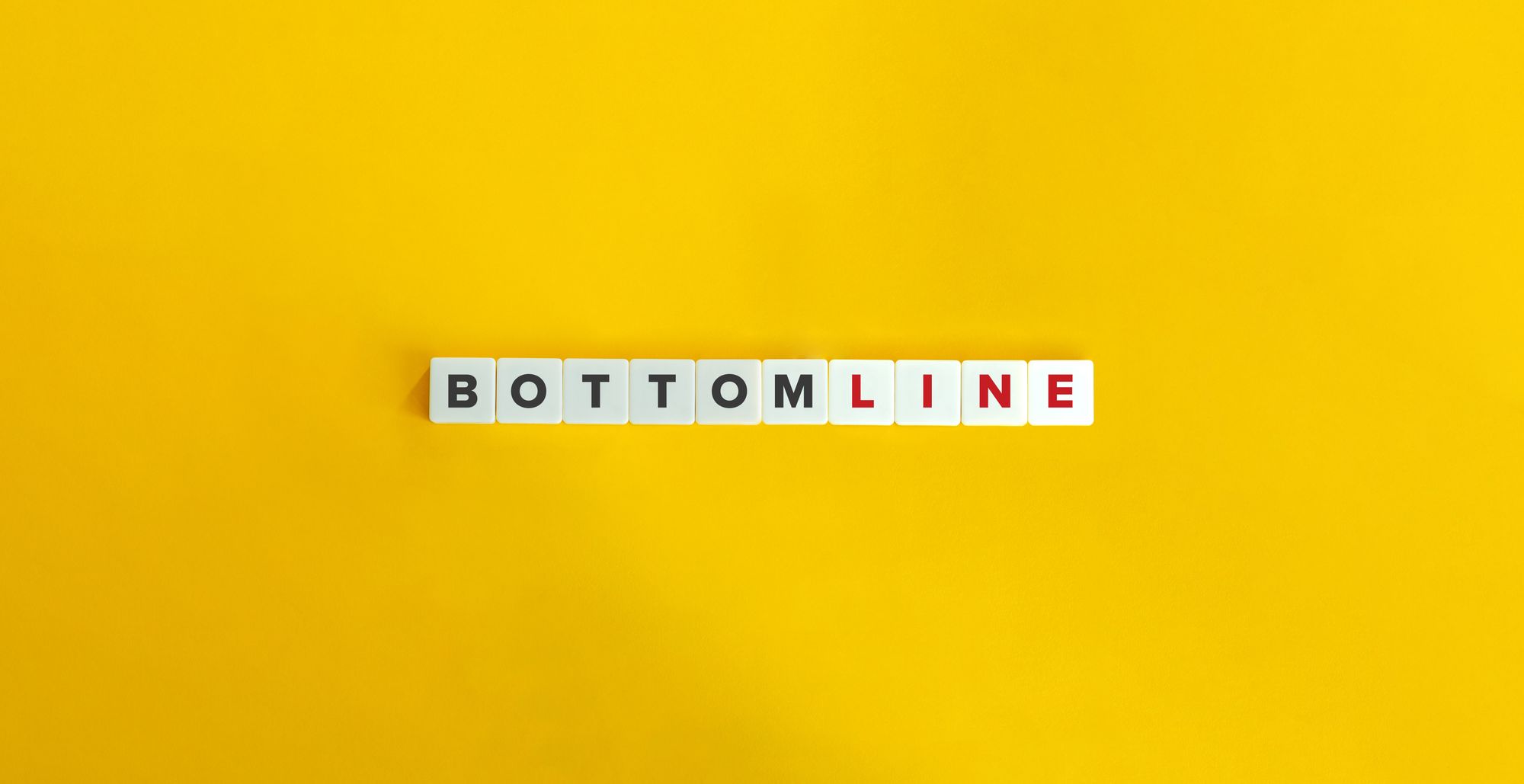 a white square tiles with black and red letters on a yellow background
