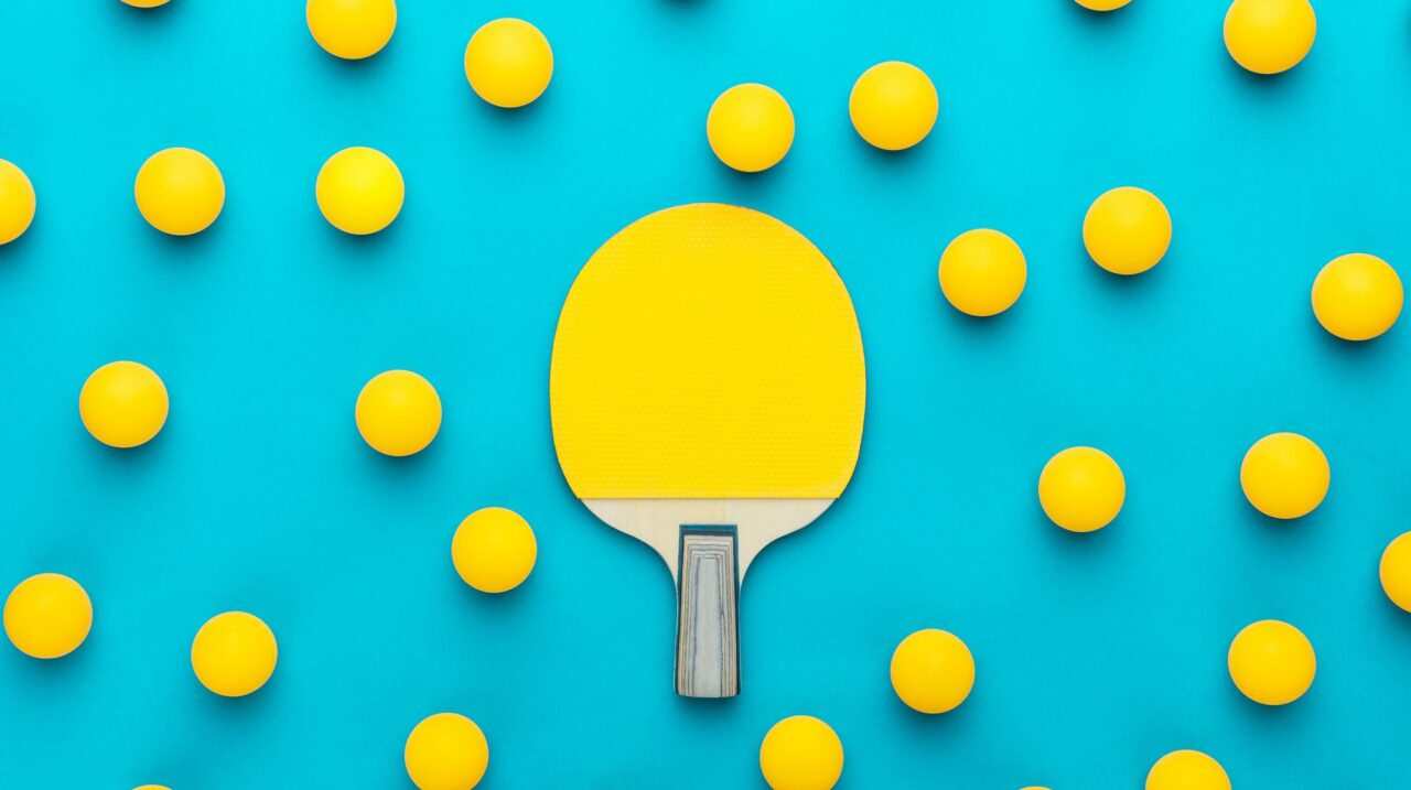 a paddle and balls on a blue surface