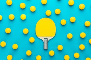 a paddle and balls on a blue surface