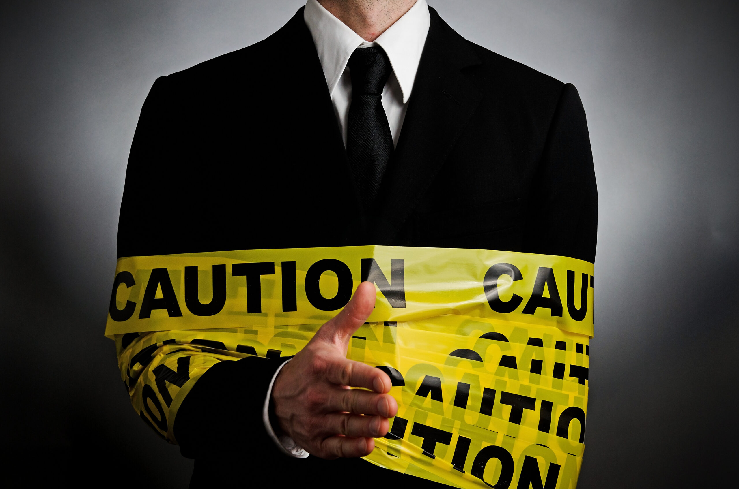 A Man In A Suit With A Caution Tape Around His Arm