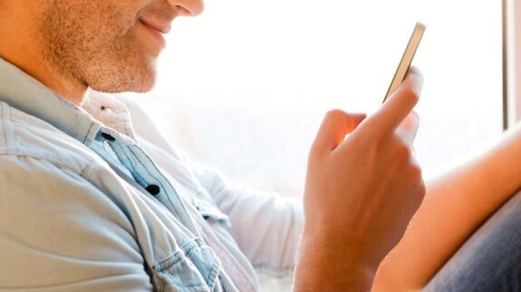 man-reading-personalized-car-buying-sms man reading personalized car-buying sms