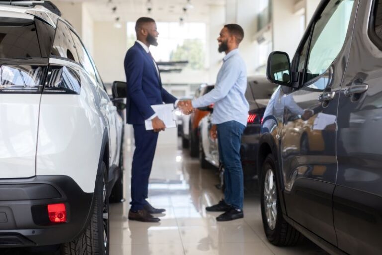 Auto Showroom Manager Shaking Hands With Young Man