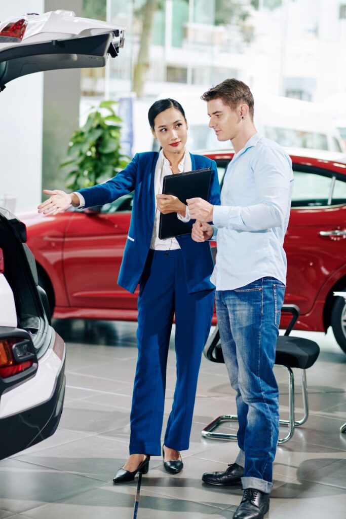 Organic Vs. Paid Automotive Lead Generation: What Works Best? 1 Manager Showing Car Trunk To Customer
