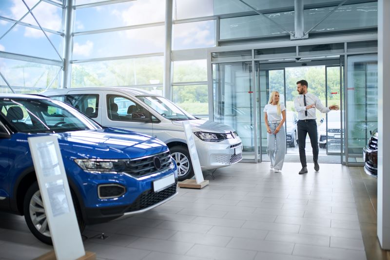 salesman showing cars to local female client