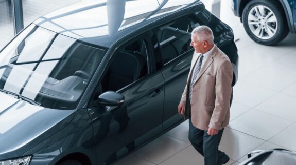 lead in formal wear walking in the automobile salon